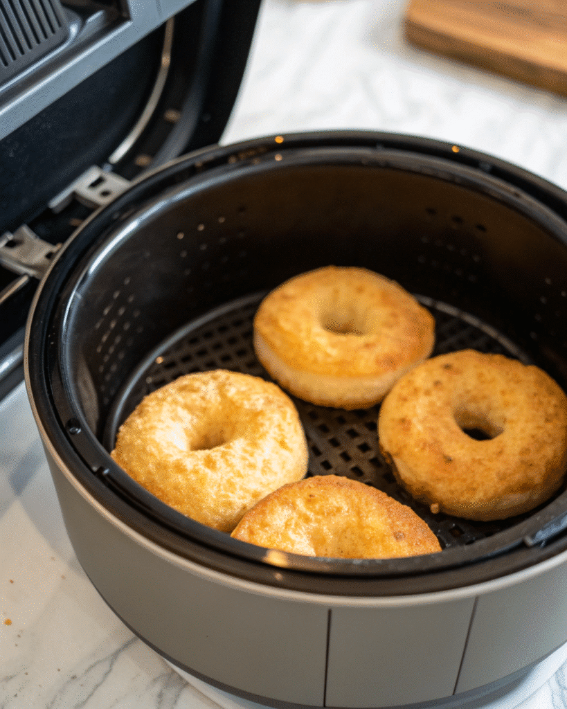 Donuts cooking inside air fryer basket